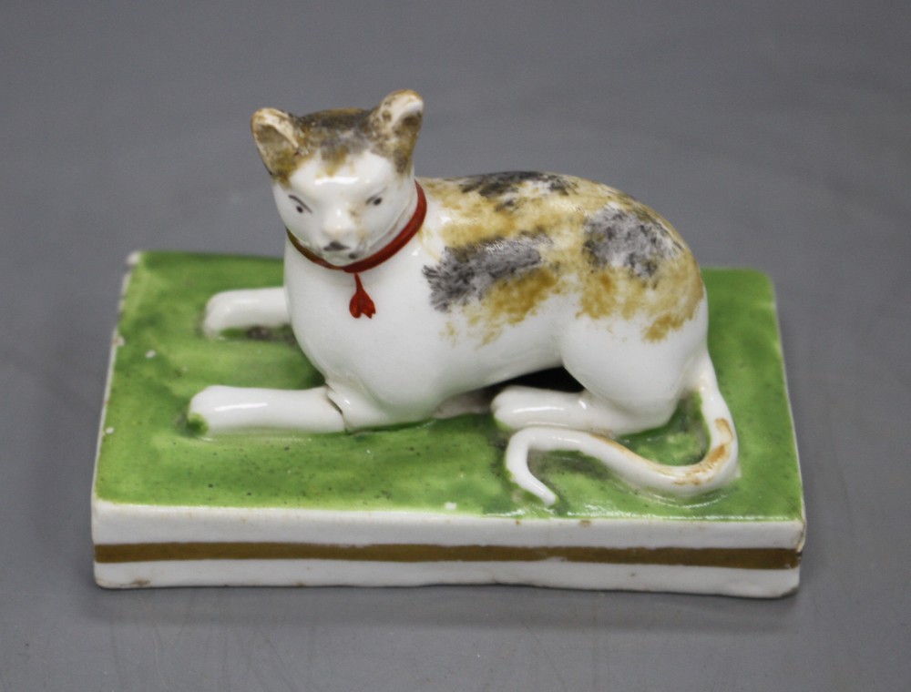 A rare Staffordshire porcelain figure of a recumbent tortoiseshell cat, c.1835-50, L. 7.5cm